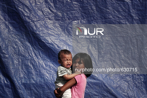 An image available on June 8, 2015 Karo girl hugging her sister crying in temporary shelters after they were evacuated from the memorial rai...
