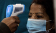 A healthcare worker checks temperature of a volunteer during dry run or a mock drill for C...