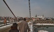 Kashmiri men walk over a bridge near Jama Masjid after fresh snowfall in Sopore town of di...