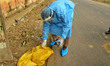 Forest department official picks up a sick crow from a roadside near Jal Mahal in Jaipur,...