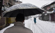 People walk amid heavy snowfall as snowfall contimues for third day in Srinagar, Indian Ad...