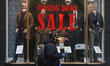 A man walks by a shop with Closing Down Sale inscription in the window, in Dublin city cen...