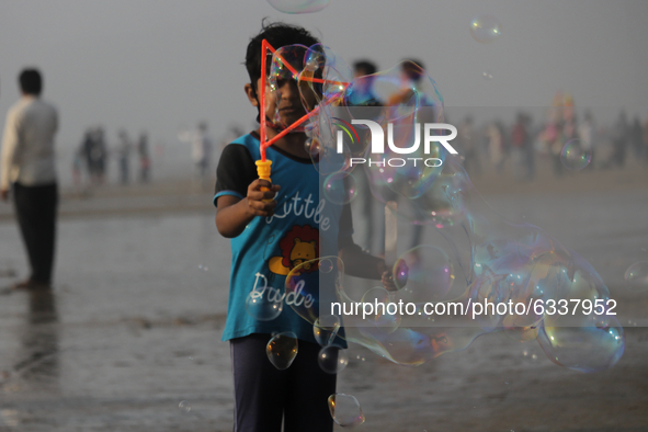 A boy makes soap bubbles at the beach in Mumbai, India on January 10, 2021. 