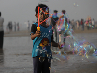 A boy makes soap bubbles at the beach in Mumbai, India on January 10, 2021. (