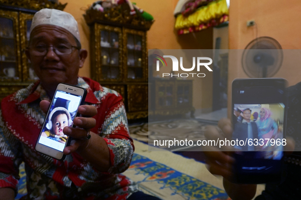 Riski Simamora and Abdul Khaliq showing a photo of Indah Halima Putri and her son Arka at their residence in Sungai Pinang, Ogan Ilir Regenc...