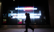 A man wearing a face mask walks past a temporarily-closed branch of sportswear retailer Sp...