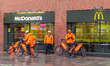 Just Eat delivery men in protective face masks are seen waiting for their order in front o...