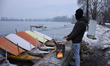 A man warms his hands besides frozen Dal Lake, Srinagar, Indian Administered Kashmir on 14...