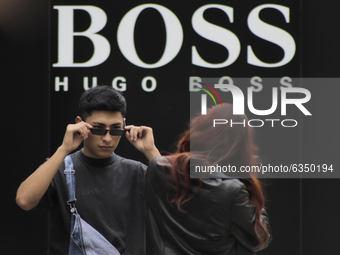 Young people take photos outside the Hugo Boss store in the exclusive Polanco area of ​​Mexico City, where some restaurants and stores in th...
