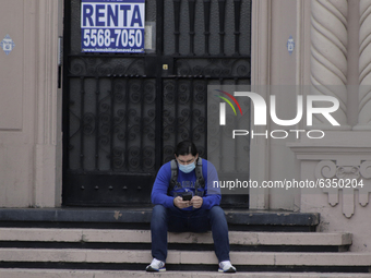 A person sits outside a rental establishment in the exclusive area of ​​Polanco, Mexico City, during the epidemiological red light and the h...
