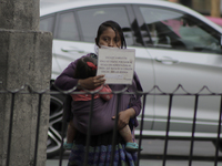 A woman asks for the help of some coins from motorists and passersby in the exclusive area of ​​Polanco, Mexico City, during the red epidemi...