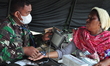 An earthquake survivor is being checked for health by Indonesian National Army personnel a...