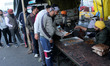 Farmers line up in a queue for 'jalebi' (sweet snack) at the community kitchen during a pr...