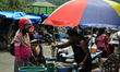 A trader is measuring the weight of shrimp in a scale, before giving it to buyers at the n...