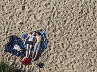 Young people relaxing on a beach under the Poniatowski bridge on the Wisla river in Warsaw. June 12, 2015, Warsaw, Poland
 (