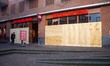 Damaged Dirk van den Broek super market with the windows boarded up with wood panels after...