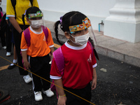 Elementary school students wearing a face shield as a preventive measure arriving at Sri Iam Anusorn School on February 1, 2021 in Bangkok,...