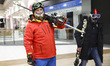 Winter sports enthusiasts wearing ski outfits and carrying ski gear walk inside Forum shop...
