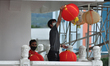 A servant for a house of worship, is putting up red lanterns to welcome the Chinese New Ye...