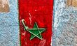 Doorway painted with the image of the Moroccan flag on a small home in the town of Moulay...