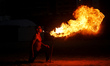 A Palestinian man show his skills with perform fire breathing on Gaza Beach during sunset,...