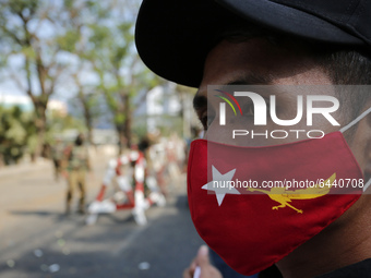 A Myanmar protester wears a facemask of the National League for Democracy (NLD) party as he takes part in a demonstration against the milita...