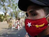 A Myanmar protester wears a facemask of the National League for Democracy (NLD) party as he takes part in a demonstration against the milita...