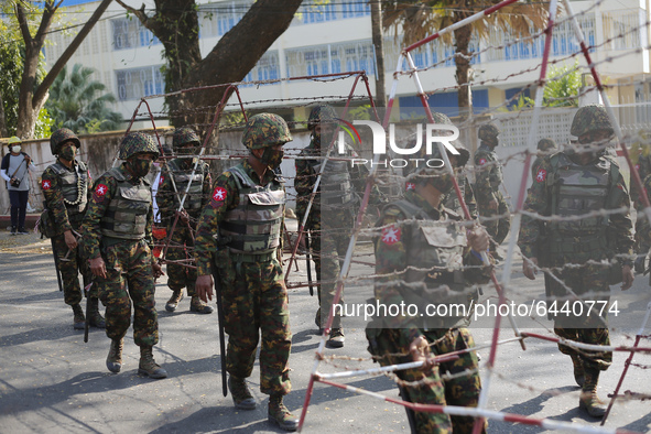 Myanmar soldiers set up barricades during a demonstration against the military coup outside the Central Bank in Yangon, Myanmar on February...