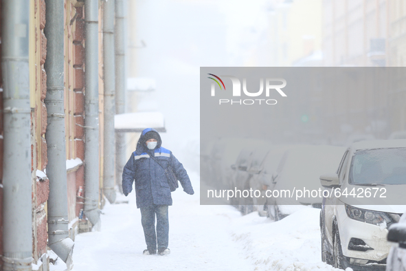 A man walks down the street during a heavy snowfall in St. Petersburg, Russia, on February 16, 2021. 