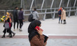 An Iranian woman speaks on her smartphone while standing near a bridge that is equipped wi...