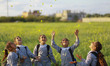 Palestinian refugee schoolgirls dressed in refugee's uniforms throw the flowers as they pl...