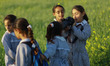 A Palestinian schoolgirl carries a secondary camera's of the photographer as she takes a p...