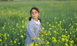 A Palestinian refugee schoolgirl picks flowers in a field of flowers in central of Gaza St...