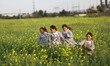 Palestinian refugee schoolgirls dressed in refugee's uniforms walk among flowers of a fiel...
