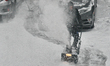 Man uses a snowblower to clear his driveway as a snowstorm dropped 10-15 centimeters of sn...