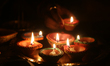 Hindu devotee holds a diya (small clay lamp) during the festival of Diwali at a Hindu temp...