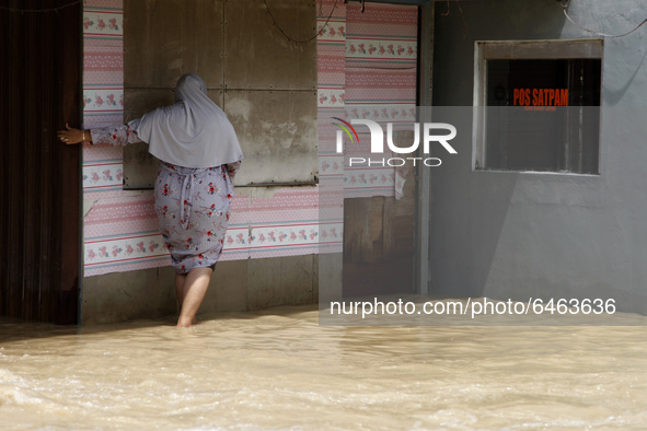 Residents crossing the floods in Pebayuran sub-district, Bekasi regency, West Java, on February 22, 2021. Massive floods hit a number of vil...