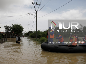 People wades floods in Pebayuran sub-district, Bekasi regency, West Java, on February 24, 2021. Massive floods hit a number of villages in B...