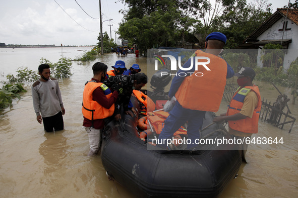 Police officers evacuate an elderly man during floods in Pebayuran sub-district, Bekasi regency, West Java, on February 22, 2021. Massive fl...