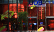 People walk past a United Overseas Bank Ltd (UOB) branch in the central business district...