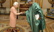Queen Elizabeth II shakes hands with Mr Abderahamane Assane Mayaki the Ambassador of the R...