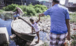 A father helping his son to get on a boat on 20th June 2015 in Dhaka, Bangladesh
