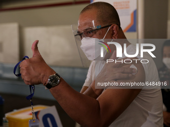 A man gives the thumbs up sign after getting inoculated with the Sinovac COVID19 vaccine during a ceremonial vaccination program held inside...
