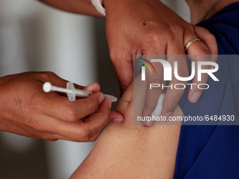 A nurse administers the Sinovac COVID19 vaccine during a ceremonial vaccination program held inside a sports stadium in Marikina City, east...