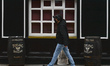 A man wearing a face mask walks by a closed pub in Dublin city center during Level 5 Covid...