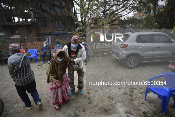 A family member helps to bring Nepalese People above 65 to get first dose of COVID19 vaccines developed by Oxford- AstraZeneca Plc at Bal Ku...