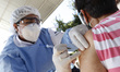 A person receives a dose of Pfizer-BioNTech Covid-19 vaccine before inject to an elderly,...