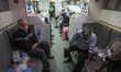 Iranian men who have infected by the COVID-19, sit at an ambulance bus before transferring...