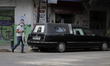 A passerby walks in front of a carriage and funeral home near the COVID-19 Dr. Rodolfo Ant...