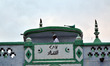 Indian muslim priest walks on the roof of a mosque as he waits for evening prayers before...